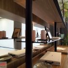 A differenza di una parete piena, una libreria con struttura aperta permette alla luce e alla profondità visiva di attraversare lo spazio, creando una separazione più leggera.